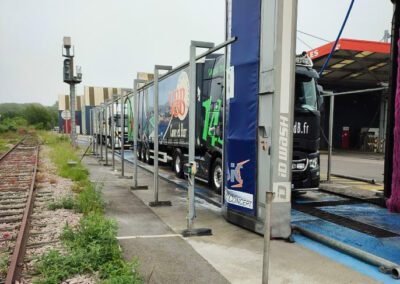 camion noir et vert sous portique de lavage gar'wash